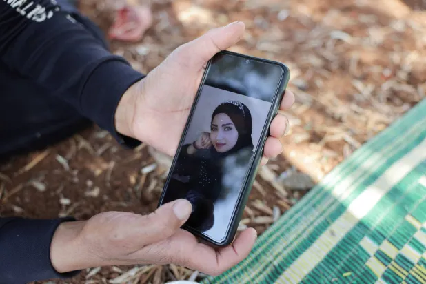 فصل صبيح التي فرَّت من القتال الطائفي في محافظة السويداء السورية تعرض صورة ابنتها المقتولة ملك بريف درعا (رويترز)