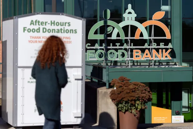  A person walks toward the entrance of the Capital Area Food Bank, Thursday, Nov. 6, 2025, in Washington. (AP Photo/Mark Schiefelbein)
