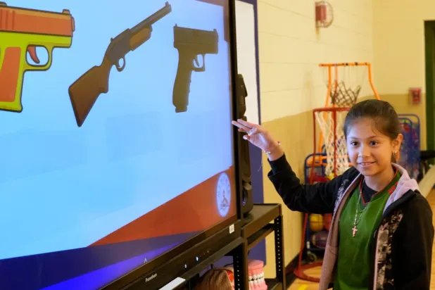 Jailyn Martinez points to a real firearm during a gun safety lesson at Berclair Elementary School, Monday, Oct. 27, 2025, in Memphis, Tenn. (AP Photo/George Walker IV)