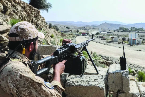 يقف أحد عناصر أمن «طالبان» حارساً على طريق قرب معبر غلام خان الحدودي بين أفغانستان وباكستان (أ.ف.ب)