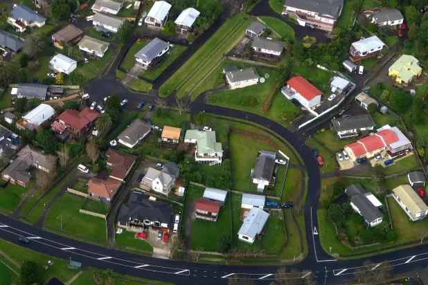 FILE PHOTO: Residential houses can be seen along a road in a suburb of Auckland in New Zealand, June 24, 2017. PREUTERS/David Gray/File Photo
