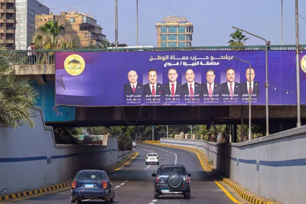 Motorists drive past a campaign billboard in Giza for the Egyptian parliamentary elections. Khaled DESOUKI / AFP
