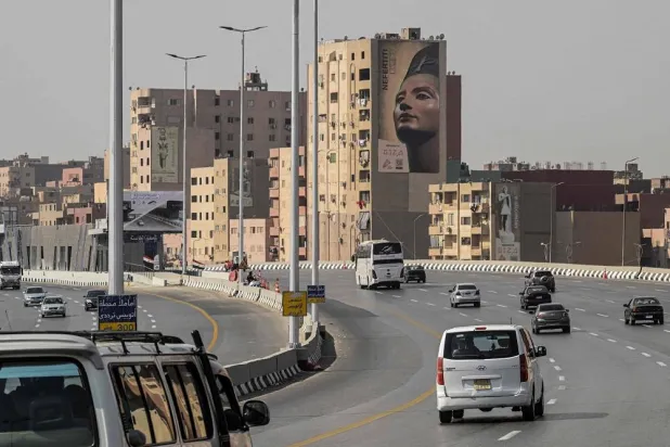 A huge banner hangs off a building along the ring road, advertising the opening of the Grand Egyptian Museum (GEM) in Giza, as vehicles drive towards the southwestern outskirts of the capital Cairo on November 1, 2025. (AFP)