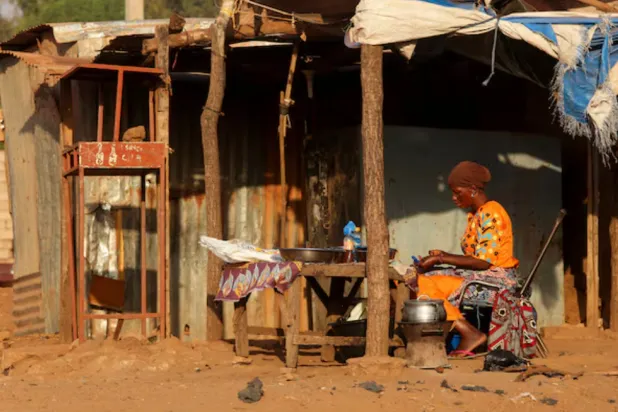 A woman prepares food on the road side, amid ongoing fuel shortages caused by a blockade imposed by al Qaeda-linked insurgents in early September, in Bamako, Mali, October 31, 2025. REUTERS/Stringer 