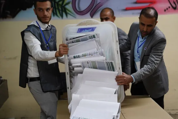 موظفون من «مفوضية الانتخابات» العراقية يفرزون أوراق الاقتراع بعد يوم التصويت الخاص في الانتخابات البرلمانية ببغداد (إ.ب.أ)