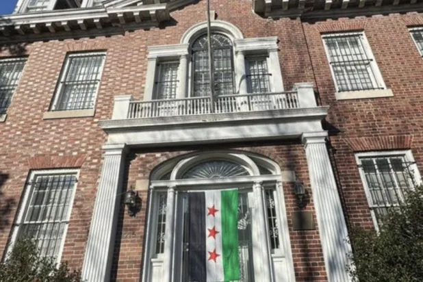 العلم السوري الجديد مرفوعا على مبنى السفارة السورية في واشنطن (أرشيفية)