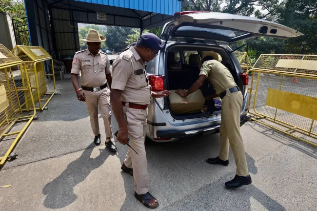 عناصر من الشرطة الهندية يتفقدون صندوق سيارة وسط إجراءات أمنية مشددة خارج مبنى فيدهانا سودها مقر المجلس التشريعي لولاية كارناتاكا في بنغالور (إ.ب.أ)