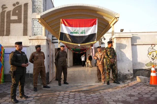 أفراد أمن خارج مركز اقتراع في البصرة (رويترز)