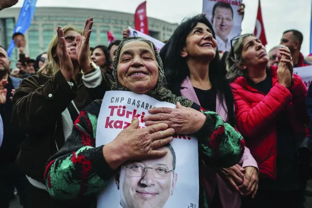 امرأة تركية تحتضن صورة لإمام أوغلو خلال تجمع في أثناء إدلائه بشهادته في اتهامه بالتجسس في إسطنبول (أرشيفية - إ.ب.أ)