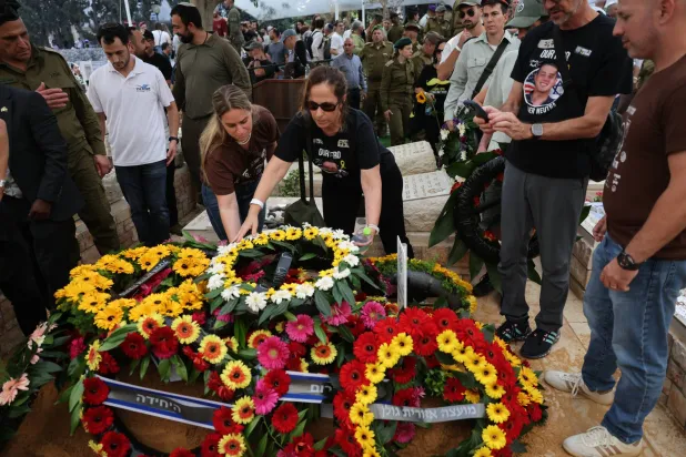 مشيعون يضعون إكليلاً على نعش الضابط هَدار غولدِن في كفار سابا (أ.ب)
