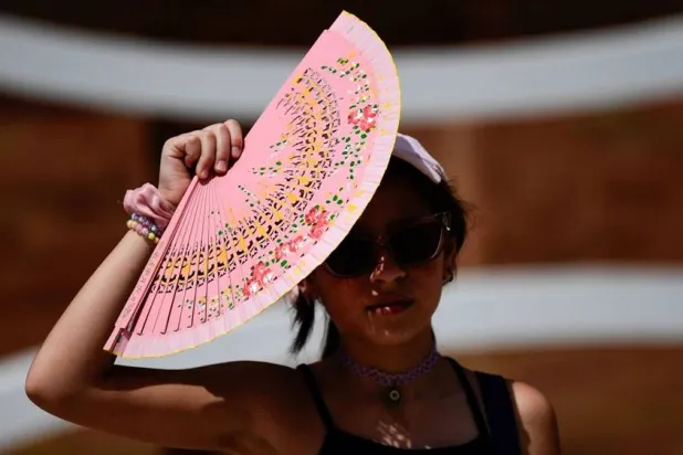  A woman protects herself from the sun with a fan during a heat wave in Seville, Spain. (Getty Images/AFP)