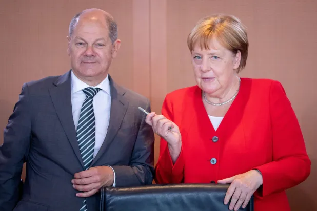 المستشاران الألمانيان السابقان أولاف شولتس وأنجيلا ميركل (د.ب.أ)