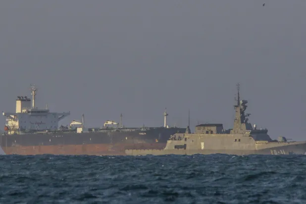 زورق دورية تابع للبحرية الفنزويلية يرافق ناقلة النفط الخام «يوسلين" التي ترفع علم بنما بالقرب من مصفاة إل باليتو في بويرتو كابيلو (أ.ف.ب)