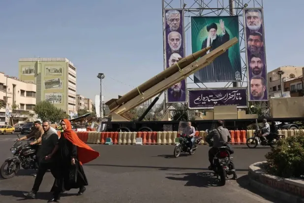 Iranian ballistic missile displayed next to a banner showing Supreme Leader Ali Khamenei and Revolutionary Guard leaders killed in Israeli strikes on a Tehran street (Reuters file photo)