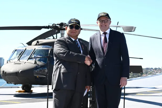 رئيس الوزراء الأسترالي أنتوني ألبانيزي ورئيس إندونيسيا برابوو سوبيانتو يلتقطان الصور بعد الإعلان عن اتفاقية أمنية على متن السفينة الحربية كانبيرا في قاعدة الأسطول الشرقية في سيدني (إ.ب.أ)