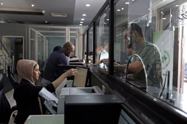  ليبي ينهي معاملة في أحد المصارف الليبية (أرشيفية - رويترز)