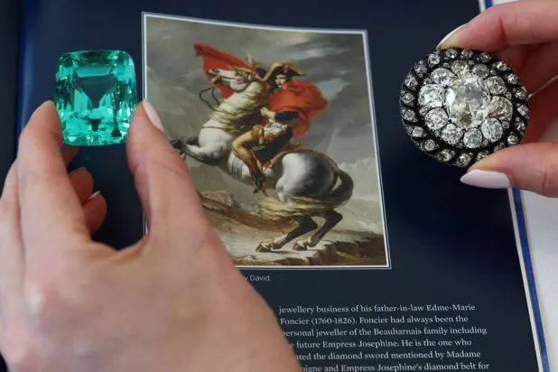 A staff member holds a 132.66 carats green beryl worn by Emperor Napoleon I at his coronation and an old mine-cut diamond brooch or pendant owned by Emperor Napoleon I during an auction preview for Sotheby’s in Geneva, Switzerland, November 6, 2025. (Reuters)