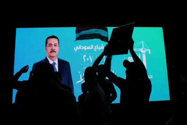 شاشة تحمل ملصقاً انتخابياً لرئيس الوزراء الحالي محمد شياع السوداني (رويترز)