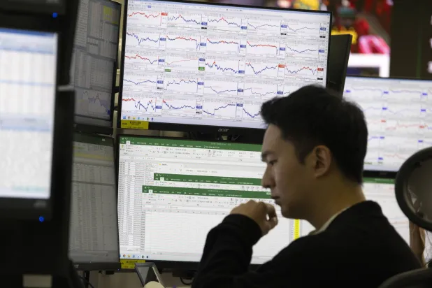 متداول يعمل أمام شاشات المراقبة في بنك هانا في سيول (إ.ب.أ)