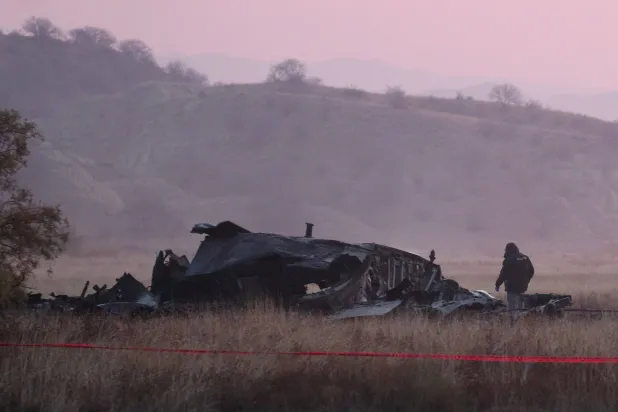A member of emergency services works at the site of the Turkish C-130 military cargo plane crash near the Azerbaijani border, in Sighnaghi municipality, Georgia, November 12, 2025. REUTERS/Irakli Gedenidze 
