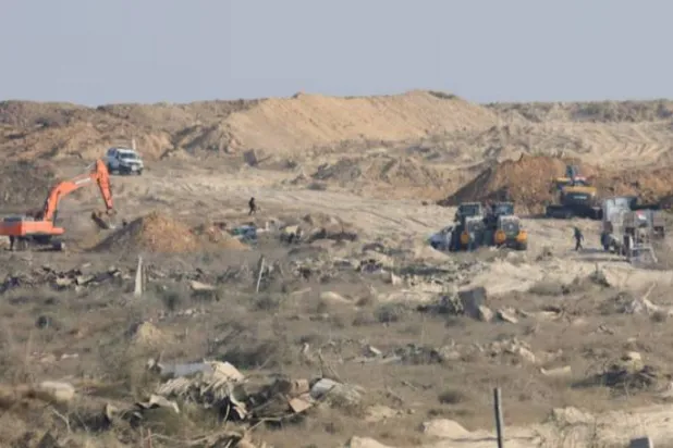 A machinery operates next to a Red Cross vehicle at an area within the so-called "yellow line" to which Israeli troops withdrew under the ceasefire, as Hamas says it continues to search for the bodies of deceased hostages seized during the October 7, 2023, attack on Israel, in Gaza City November 12, 2025. REUTERS/Dawoud Abu Alkas Purchase Licensing Rights