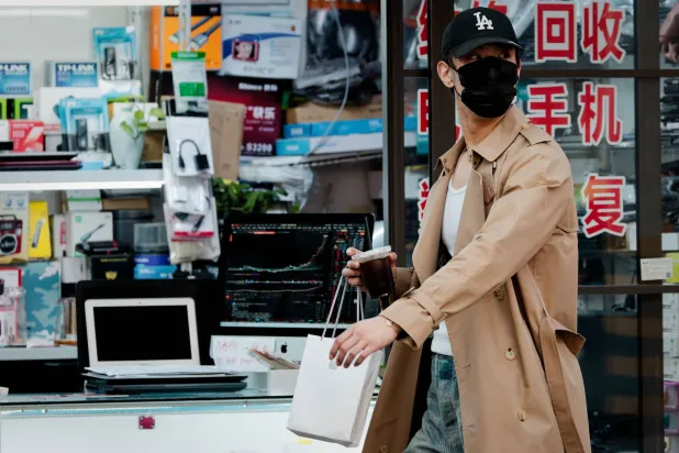 سيدة تمر أمام متجر للإلكترونيات في مدينة شنغهاي الصينية (إ.ب.أ)