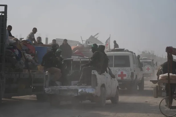 مسلحون من حركة «حماس» برفقة أعضاء من اللجنة الدولية للصليب الأحمر يتجهون إلى شرق مدينة غزة للبحث عن جثث الرهائن (أ.ب)