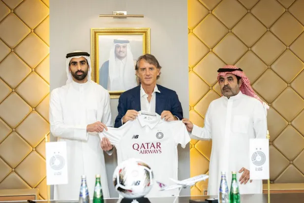 مانشيني خلال توقيعه للسد القطري (نادي السد)