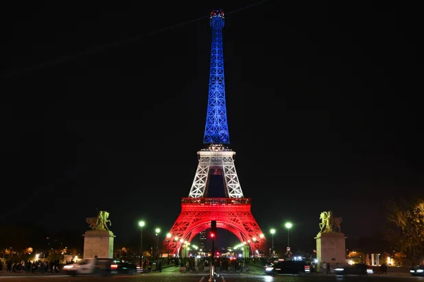 برج إيفل مضاء بألوان العلم الفرنسي تكريماً لضحايا الهجمات الإرهابية بباريس الأربعاء (د.ب.أ)