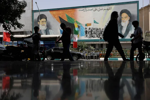 FILE PHOTO: People walk next to a mural with a picture of Iran's Supreme Leader, Ali Khamenei, on a street, early hours of ceasefire, in Tehran, Iran, June 24, 2025. Majid Asgaripour/WANA (West Asia News Agency) via REUTERS   ATTENTION EDITORS - THIS PICTURE WAS PROVIDED BY A THIRD PARTY/File Photo