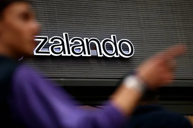 A person stands next to the logo of fashion retailer Zalando in Berlin, Germany, November 13, 2025. REUTERS/Lisi Niesner