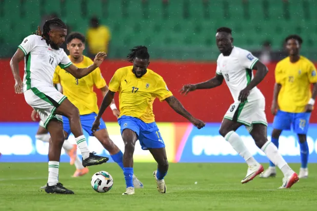 أليكس إيوبي لاعب نيجيريا في صراع على الكرة مع الغابوني أندريه بوكو (رويترز)