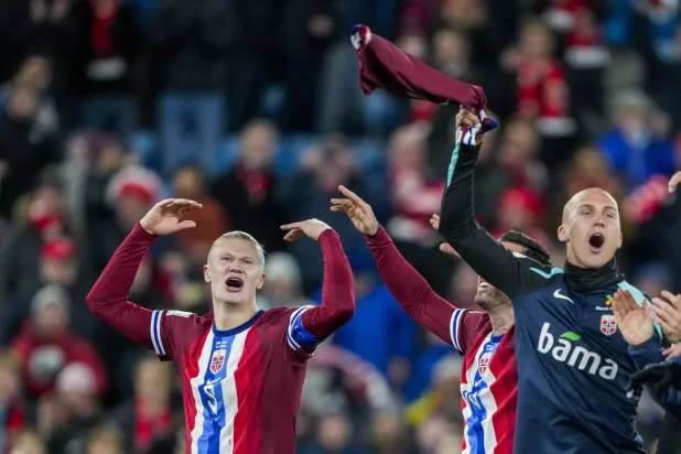 يحتفل النرويجي إرلينغ براوت هالاند (يسار) وزميله ليو سكيري أوستيغارد بالفوز (رويترز)