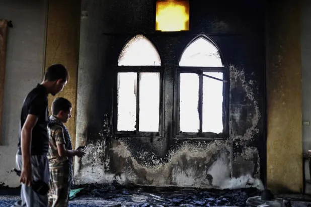 Filistinliler, işgal altındaki Batı Şeria'da Salfit yakınlarındaki Deyr İstiya köyündeki El-Hacı Hamida Camii'ne yerleşimcilerin dün verdiği zararı inceliyor (AFP).