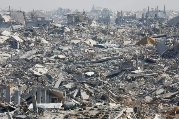 Palestinians stand next to the rubble of destroyed buildings, amid a ceasefire between Israel and Hamas, in Gaza City, November 2, 2025. REUTERS/Mahmoud Issa