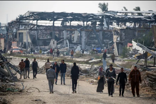 فلسطينيون يسيرون على طول طريق صلاح الدين بالنصيرات في طريقهم إلى الجزء الشمالي من قطاع غزة (أ.ف.ب)