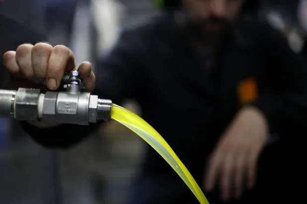 رجل يعمل داخل مصنع لإنتاج زيت الزيتون في جنوب فرنسا (إ.ب.أ)