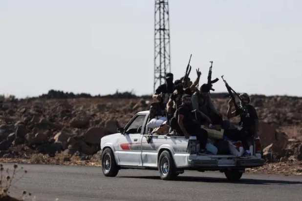 مسلحون على متن سيارة بالسويداء في يوليو الماضي (أرشيفية - رويترز)