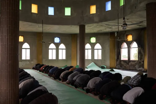 فلسطينيون يؤدون صلاة الجمعة في المسجد الذي أحرقه المستوطنون الإسرائيليون (أ.ب)