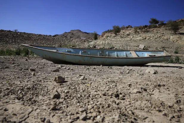 قارب مهجور يرقد في خزان مائي جفّ بفعل الجفاف على مشارف صنعاء (إ.ب.أ)