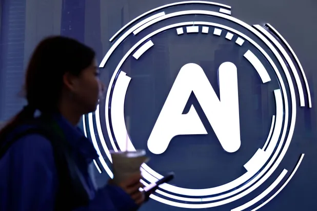 سيدة تمر بجوار لافتة كتب عليها «الذكاء الاصطناعي» في معرض حول الإنترنت بالصين (رويترز)