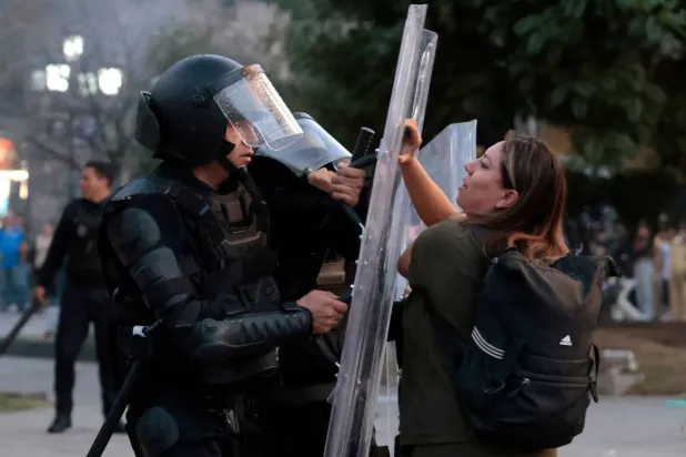 Guadalajara'da Meksika Cumhurbaşkanı Claudia Sheinbaum'un hükümetine karşı düzenlenen yürüyüşte çıkan çatışmalarda bir protestocu polis memuruyla karşı karşıya geliyor (AFP)