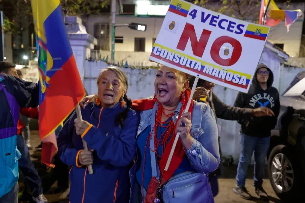 سيدتان من الإكوادور تحتفلان بعد ظهور نتائج أولية تشير لرفض عودة القواعد العسكرية الأميركية للبلاد (إ.ب.أ)