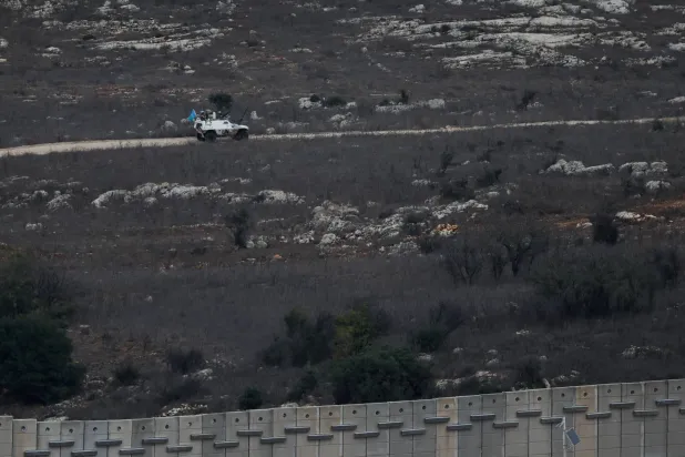 A UN vehicle drives near a concrete wall along Lebanon's southern border which, according to the Lebanese presidency, extends beyond the "Blue Line", a UN-mapped line separating Lebanon from Israel and the Israeli-occupied Golan Heights, as seen from northern Israel, November 16, 2025. REUTERS/Shir Torem
