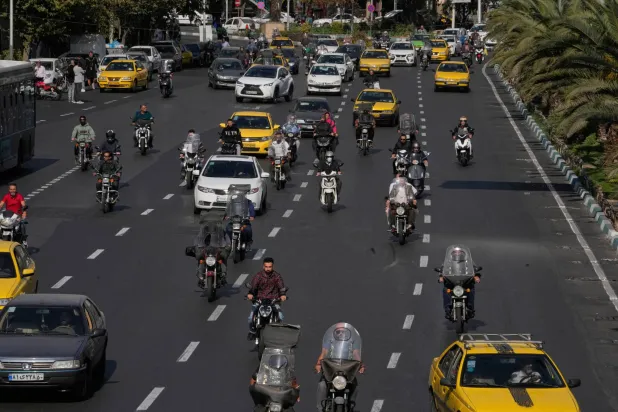 People drive their motorbikes in downtown Tehran, Iran, Saturday, Nov. 1, 2025. (AP Photo/Vahid Salemi)