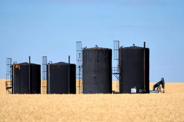 Oil pumpjacks and tanks are pictured in a farmer’s field near Kindersley, Saskatchewan, Canada September 5, 2024. REUTERS/Todd Korol