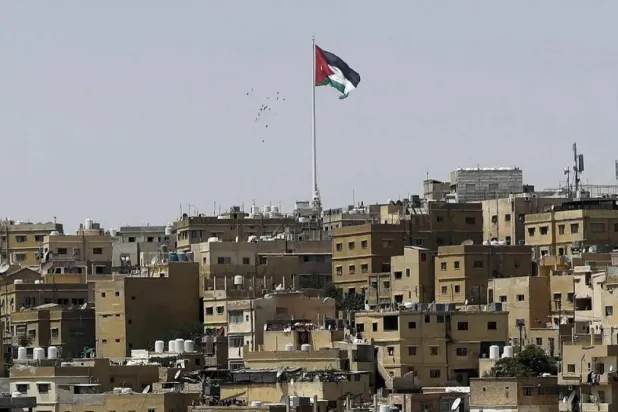  A general view taken from Jabal Al Qala district shows a Jordanian flag fluttering above the Jordanian capital Amman. (AFP) 