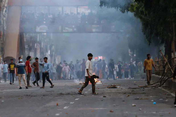 مناوئون للشيخة حسينة خلال صدامات مع الشرطة بعد صدور حكم الإعدام بحقها في داكا أمس (رويترز)