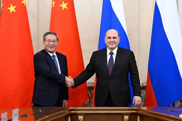 Rusya Başbakanı Mihail Mişustin (sağda) Çin Başbakanı Li Çiang ile tokalaşırken (EPA)