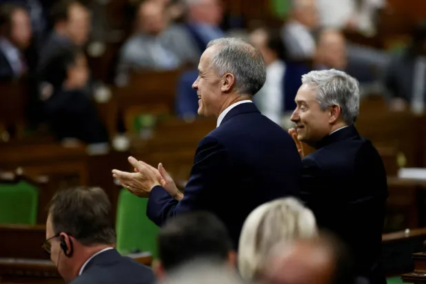 رئيس وزراء كندا مارك كارني ووزير المالية فرانسوا - فيليب شامبان يصفقان في مجلس العموم بأوتاوا 17 نوفمبر 2025 (رويترز)